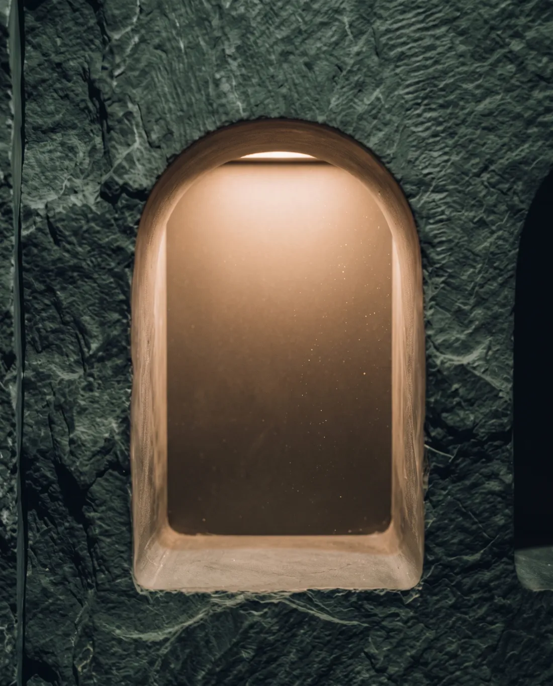 An empty, lit stone niche waiting to be filled